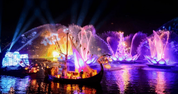 Dazzling Rivers of Light show at Disney World, with glowing boats and fountains shimmering on the lake under the night sky.