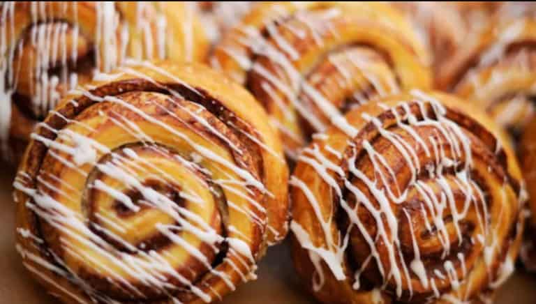 Warm cinnamon rolls topped with sweet white icing, packed together— a must-try snack for Disney World park-goers.
