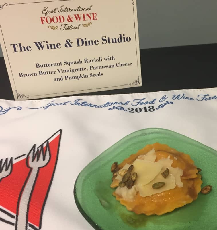 Butternut squash ravioli topped with cheese and seeds at Disney’s Epcot Food & Wine Festival 2018, served on a green plate.
