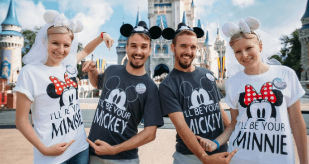 Matching twin couples rock Mickey and Minnie shirts and ears while smiling in front of Cinderella Castle at Disney World.