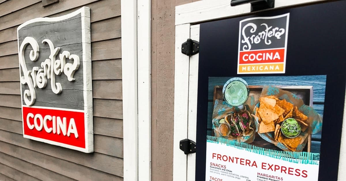 The Frontera Cocina Mexicana sign and menu outside welcome Disney Springs visitors to a vibrant dining spot at Walt Disney World.