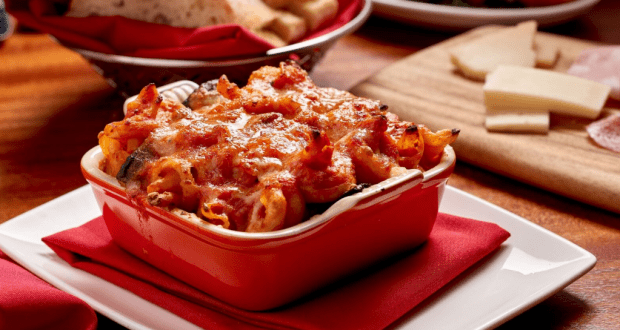 Cheesy baked pasta in a red dish at Morimoto Asia, served on white plate with bread—perfect for Magical Dining Month at Disney.