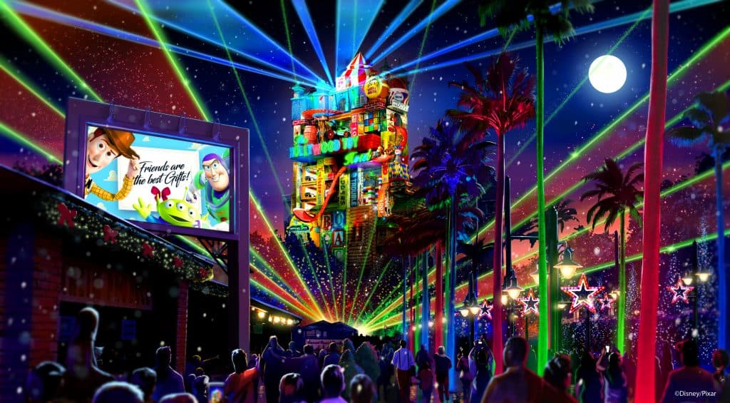 Laser lights dazzle Hollywood Studios guests at night by Tower of Terror, with a Toy Story billboard shining in the background.