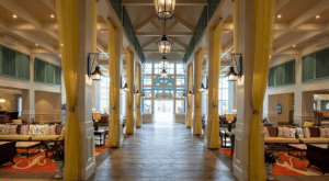 Caribbean Beach Resort lobby near Disney World, featuring high ceilings, yellow drapes, cozy seating, and sunlit windows.