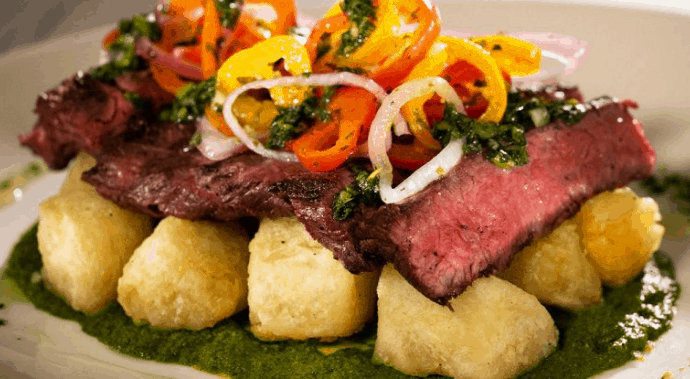 Steak and fried gnocchi with cherry tomatoes, onions, and herbs on green sauce at Sebastian’s Bistro, Disney World.