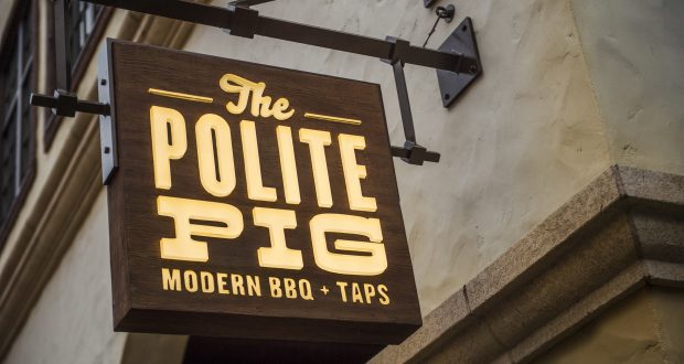 The Polite Pig Modern BBQ + Taps sign greets Disney Springs guests, promising flavorful barbecue in a lively Disney setting.