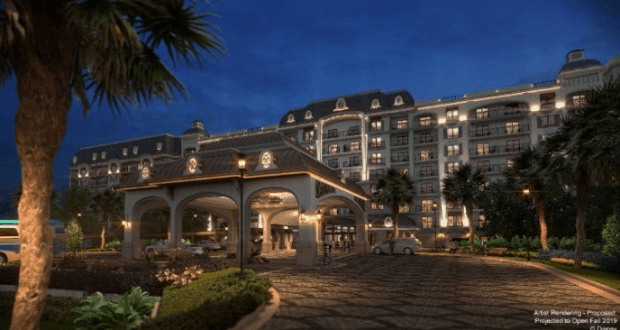 Charming Riviera Resort–inspired hotel with arched entry, glowing lights, and lush gardens at dusk—perfect Disney World getaway!.