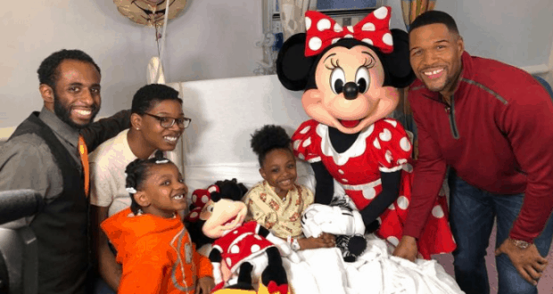 Minnie Mouse brings Disney joy to a hospital room as four adults and two kids celebrate with a transplant recipient by the bedside.