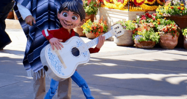 Miguel from "Coco" rocks his signature white guitar among vibrant flowers at Epcot, bringing Coco’s magic to life for guests.