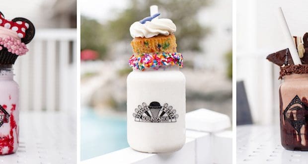Three mason jar milkshakes topped with colorful cupcakes, cookies, brownies, and whipped cream like Disney World’s iconic shakes.