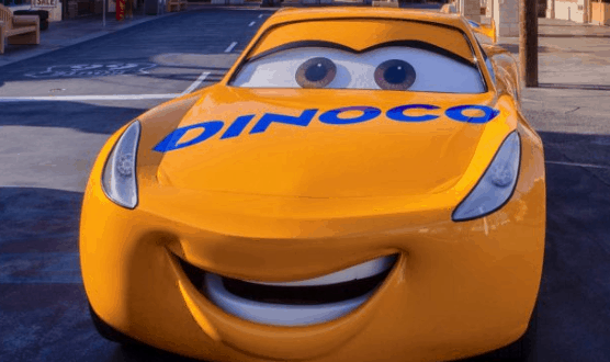 Dinoco’s yellow race car smiles on a city street, just like Lightning McQueen at Disney's Hollywood Studios in Walt Disney World.