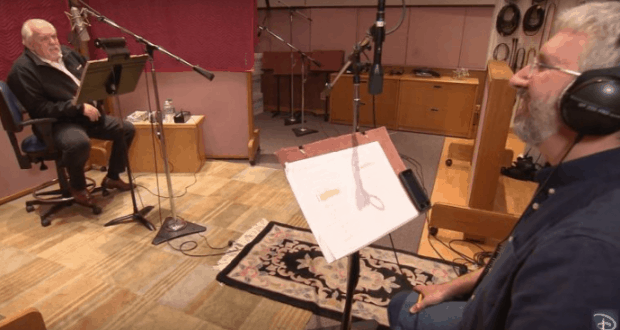 Inside a Disney recording booth, two voice actors sit across from each other with mics and stands, creating magic for guests.