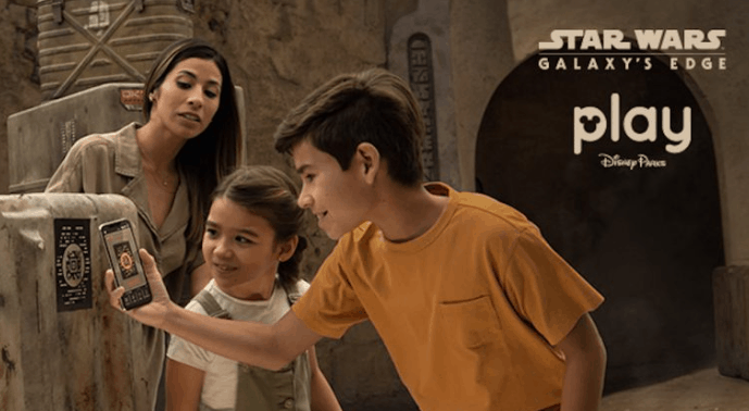 Visitors at Black Spire Outpost in Star Wars: Galaxy's Edge use the Play Disney Parks App to enhance their immersive adventure.