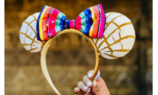 Golden headband with white and gold ears inspired by conchas, topped with a vibrant striped bow, perfect for Disney Parks fans.
