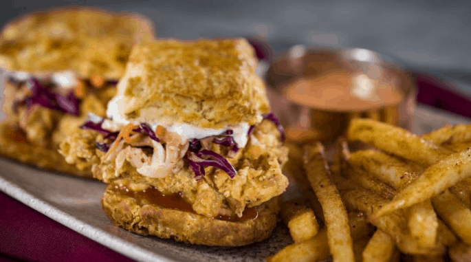 Savor a classic sandwich and crispy fries at Three Bridges Bar & Grill in Disney’s Coronado Springs Resort—theme park dining fun!.