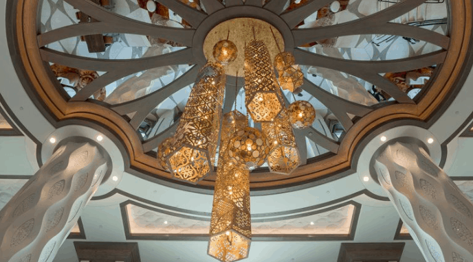 A lavish gold chandelier glows beneath a domed ceiling, echoing the grand, reimagined style of Disney’s Coronado Springs Resort.