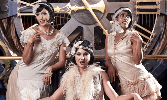 Gatsby Glam Night at The Edison: Three flapper-era guests pose by the giant clock, channeling Roaring Twenties magic.