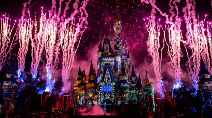Cinderella Castle dazzles at Walt Disney World, illuminated by pink fireworks and vibrant lights in a Not So Spooky Spectacular.
