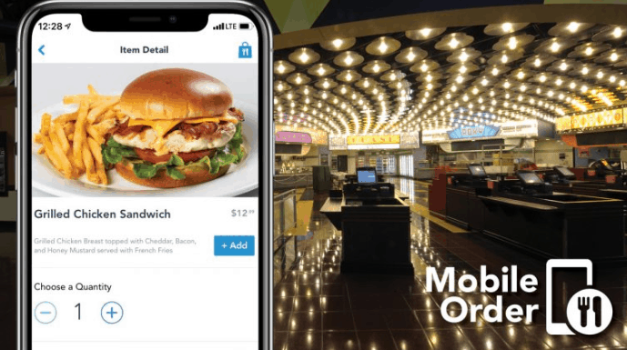 A smartphone shows a grilled chicken sandwich Mobile Order inside a brightly lit, empty Disney World quick-service restaurant.