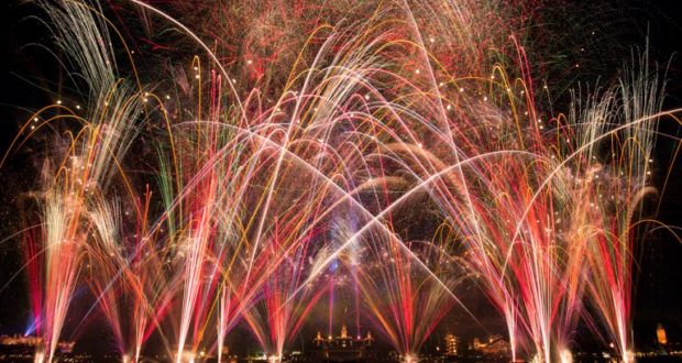 Dazzling fireworks explode over Epcot’s skyline, their colors mirrored on the lagoon, celebrating Epcot Forever at Disney World.