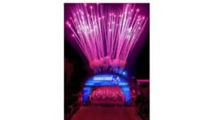 Fireworks dazzle above runners at the Walt Disney World marathon start, with a glowing blue arch setting the magical scene.