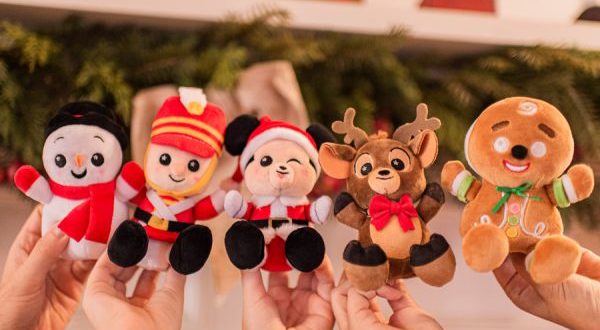 Guests show off Wishables holiday plushies—penguin, soldier, bear, reindeer & gingerbread man—at Disney Parks.