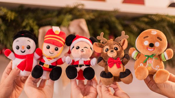 Guests show off Wishables holiday plushies—penguin, soldier, bear, reindeer & gingerbread man—at Disney Parks.