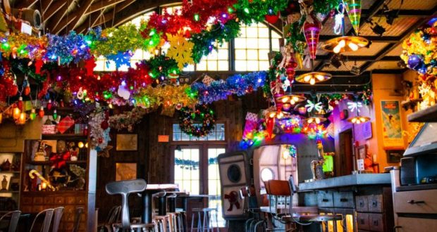 Jock Lindsey’s Holiday Bar at Disney Springs glows with festive lights, garlands, and ornaments throughout Walt Disney World.