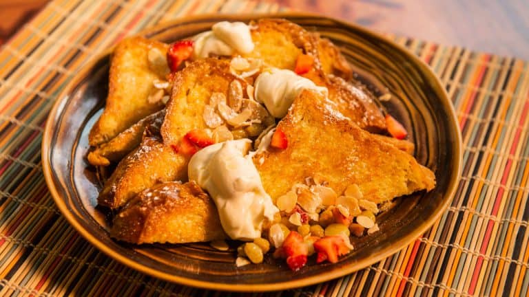 Enjoy fluffy French toast with whipped cream, strawberries, and almonds at Sanaa—an Insta-worthy Disney World breakfast.