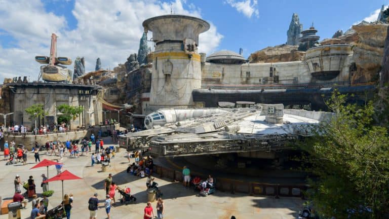 Fans flock around the full-size Millennium Falcon at Star Wars: Galaxy’s Edge, captured by a Super Zoom Magic Shot under blue skies.