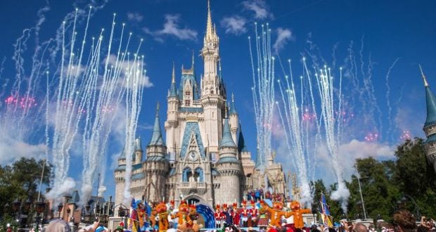 Fireworks light up Cinderella Castle as Disney characters perform onstage during the ABC Christmas Parade, delighting park guests.
