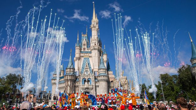 Fireworks light up Cinderella Castle as Disney characters perform onstage during the ABC Christmas Parade, delighting park guests.