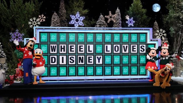 Goofy, Donald, Minnie, and Mickey spread holiday magic at Disney World with festive fun by the "WHEEL LOVES DISNEY" board.