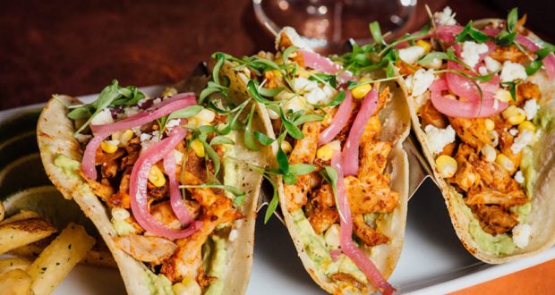 Tacos served on a plate at Disney Springs, ready to enjoy during your day of eats and entertainment at the resort.