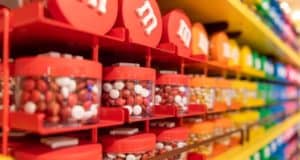 Bright M&M dispensers fill the shelves at the M&M’S Orlando Store in Disney Springs, ready for visitors to grab their favorite colors.