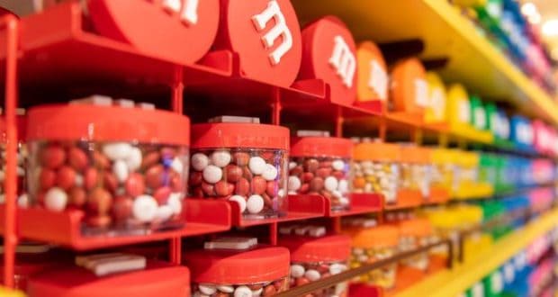 Bright M&M dispensers fill the shelves at the M&M’S Orlando Store in Disney Springs, ready for visitors to grab their favorite colors.