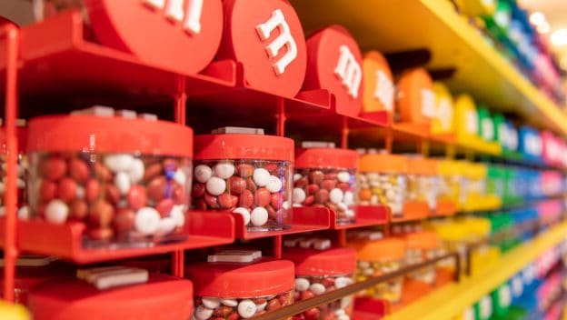 Bright M&M dispensers fill the shelves at the M&M’S Orlando Store in Disney Springs, ready for visitors to grab their favorite colors.