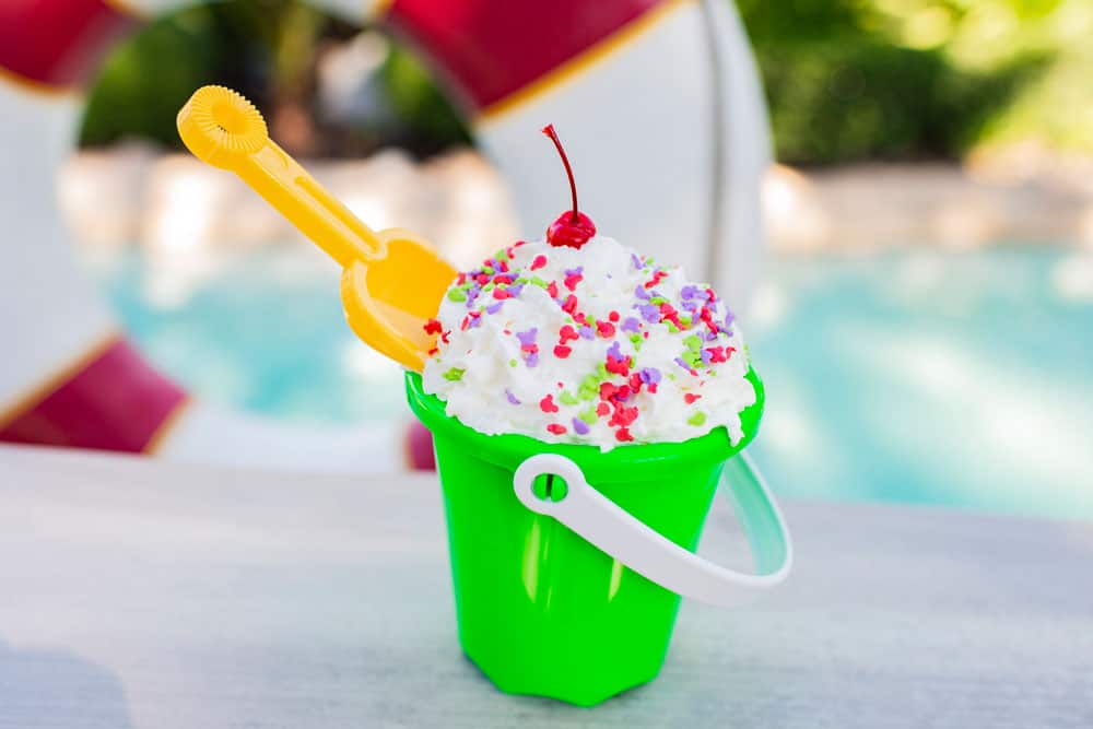 Typhoon Lagoon’s signature sundae: a green pail overflowing with whipped cream, sprinkles, cherry, and shovel by the poolside.