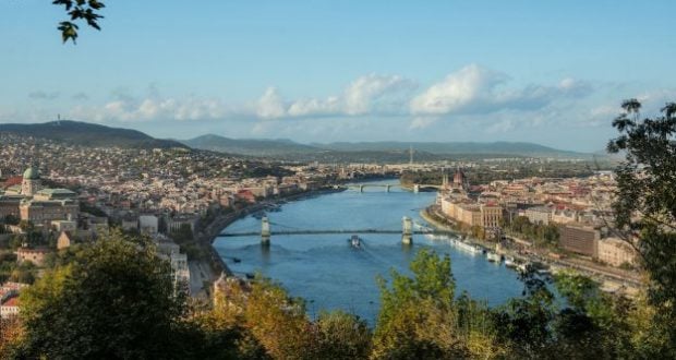 A picturesque river and bridge with a city skyline, inviting you to experience Disney magic on a European river cruise adventure.
