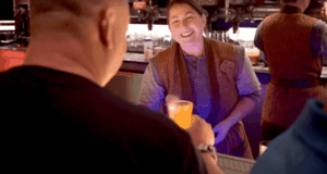 A bartender at Oga’s Cantina serves a colorful drink, immersing guests in the bustling Star Wars: Galaxy’s Edge experience.