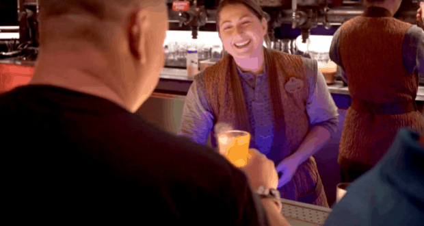 A bartender at Oga’s Cantina serves a colorful drink, immersing guests in the bustling Star Wars: Galaxy’s Edge experience.
