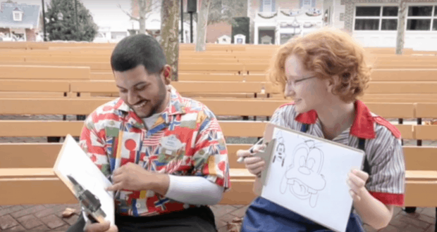 Fans challenge each other in a lively cartoon quick-draw contest, laughing and sketching on whiteboards amid theme park magic.