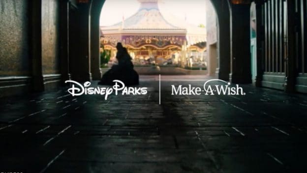 Disney and Make-A-Wish logos blend above a classic carousel, seen from a shaded walkway—iconic park magic for families.