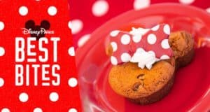Mickey-shaped chocolate chip cookie topped with whipped cream and a red polka-dot bow on a red plate—Disney Parks Best Bite.