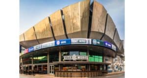 Sleek arena with striking metal panels and vibrant event screens above City Works at Disney Springs, perfect for entertainment fans.