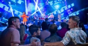 Annual Passholders revel in a live concert under blue stage lights at Epcot’s International Flower & Garden Festival.