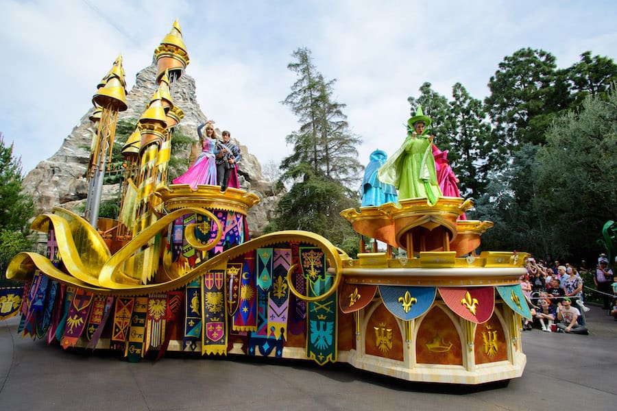 Magic Happens Parade at Disneyland Park features princesses and fairies on a vibrant castle float, enchanting park guests.