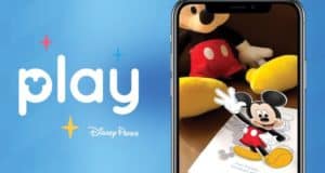 Mickey Mouse animated on a smartphone with "play" and Play Disney Parks App logo, set against a vibrant Disney Parks blue backdrop.