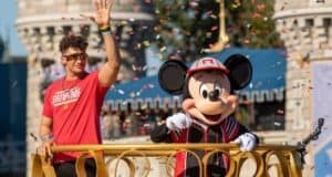 Mickey Mouse waves alongside a guest on a confetti-filled parade float at Disney World, channeling championship celebration energy.
