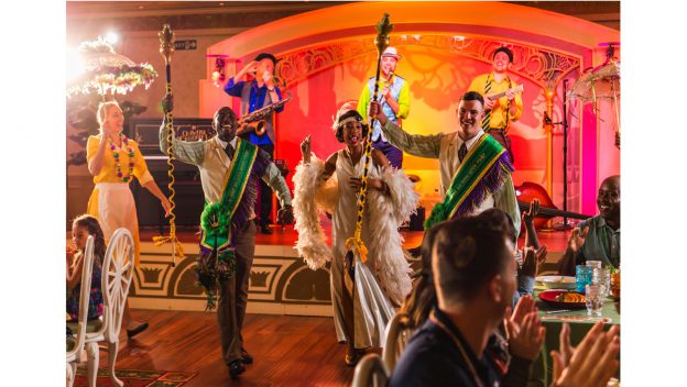 Vibrant performers sing and dance onstage as guests enjoy a New Orleans-inspired celebration aboard Disney Wonder.